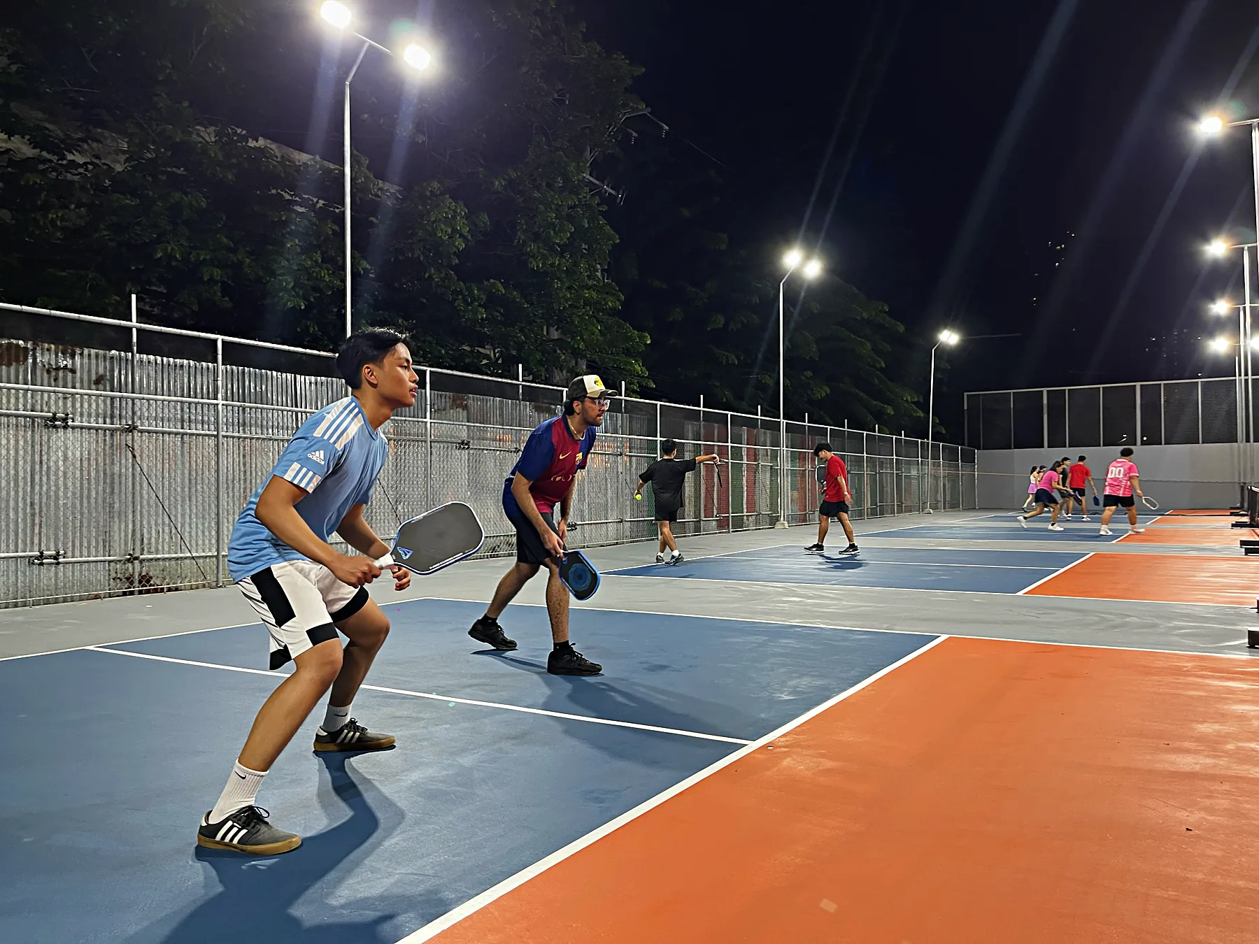A rally under the lights on a public court at night